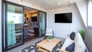 A modern living room with a sofa, a coffee table, and a TV mounted on the wall. - New 1.5 Miles to Broadway | City Views | Game Room (Nashville)