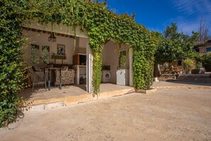 A covered outdoor area with a table and chairs, a washing machine, and a hanging light fixture. - Mobile Home 'Kenya' with Shared Pool, Wi-Fi and Air Conditioning (Le Val)