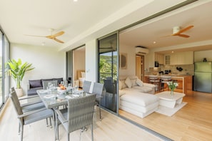 Un espacio habitable moderno con comedor, sofá y cocina.