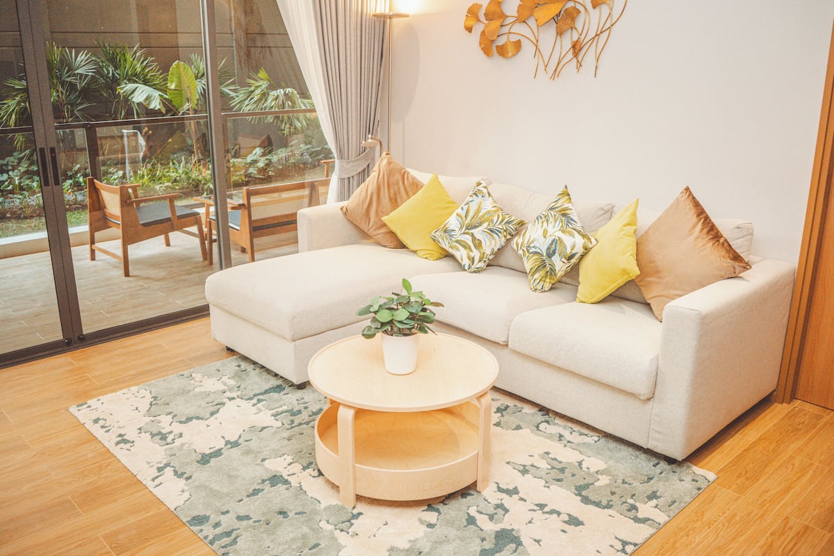 Un salon avec un canapé, une table basse ronde et une plante en pot.