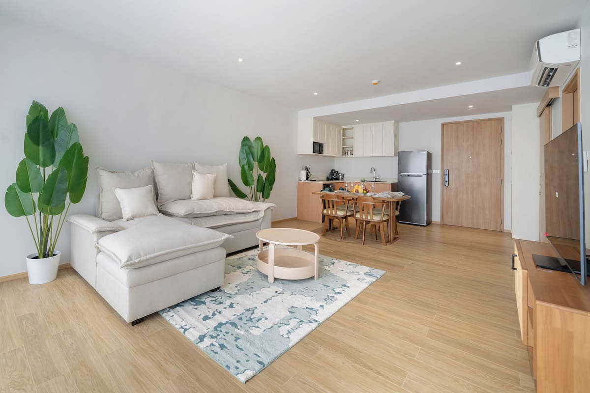 Un salon moderne comprenant un canapé, une table basse et un coin repas avec des chaises.