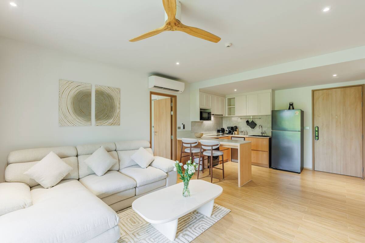 Un salon moderne avec un canapé, une table basse et un ventilateur de plafond.