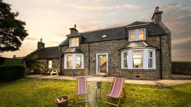 A stone house with a fire pit, two striped chairs, and a picnic table in the yard. - Barley Bank, a peaceful, tranquil dog-friendly retreat with a wood burning stove (Duffus)