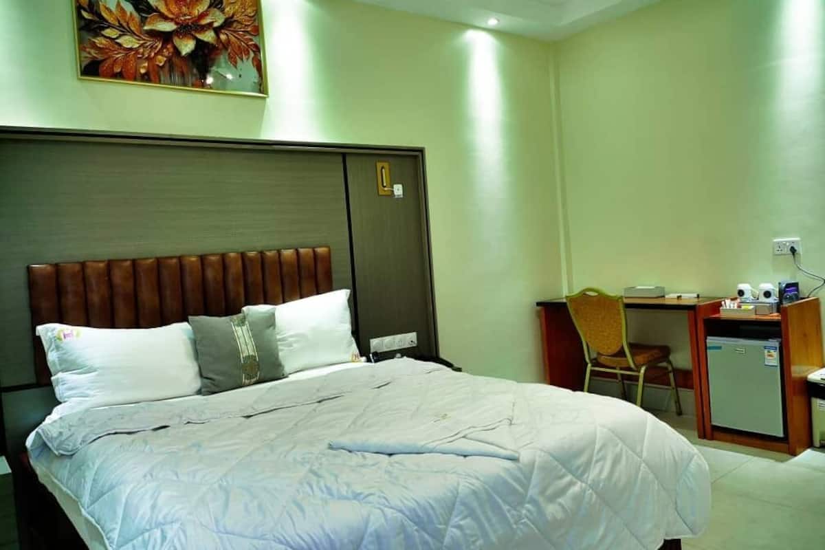 Une chambre d’hôtel avec un lit, un bureau et une chaise.