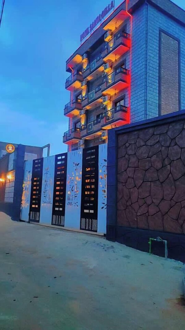 A multi-story hotel with balconies and a stone facade. - Hotel Santa Bella (Douala)