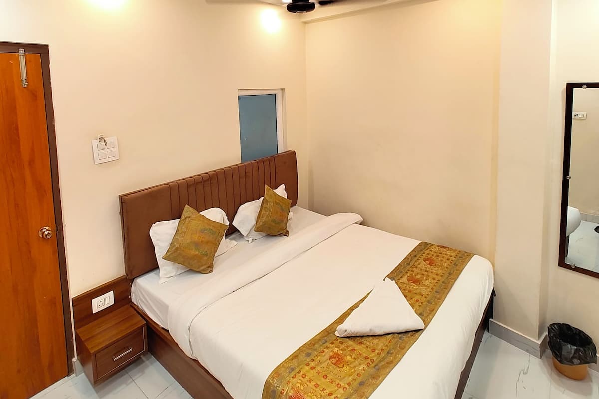 A bedroom with a bed, bedside table, and a ceiling fan.