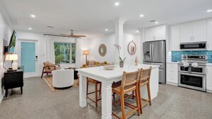 A modern kitchen with white cabinets, a stainless steel refrigerator, and a microwave. - Poolside Palms Villa 🌴 Resort-Style Pool | Near Beach 🏖️ (Fort Lauderdale)