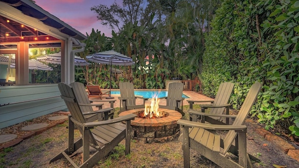 A patio with a fire pit, outdoor seating, and a pool. - Poolside Palms Villa 🌴 Resort-Style Pool | Near Beach 🏖️ (Fort Lauderdale)