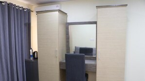 A compact room with a bed, a desk, and a wardrobe. - The Cate House Hotel (Lagos)