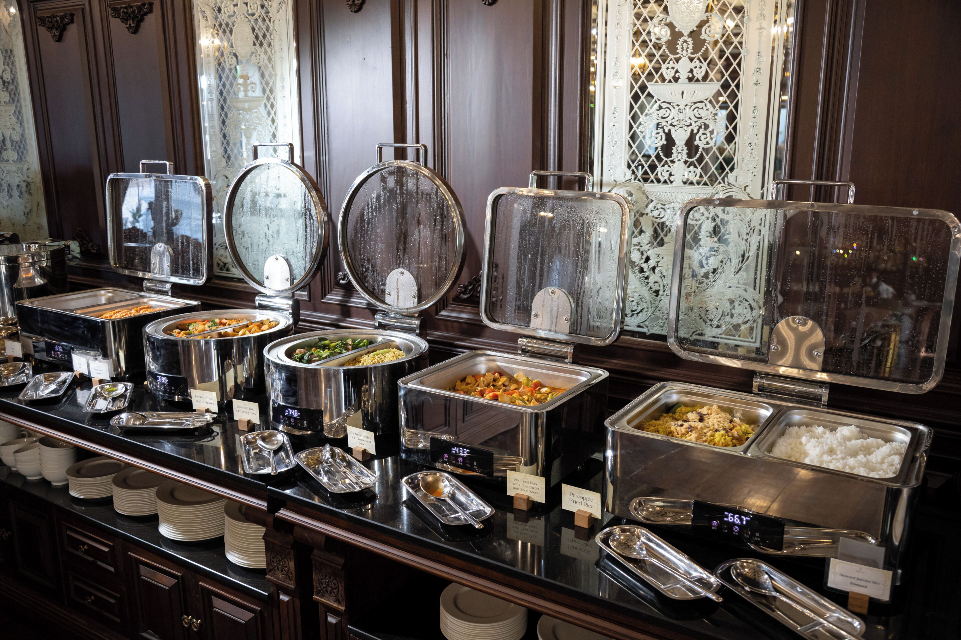A buffet with various food containers and serving utensils.