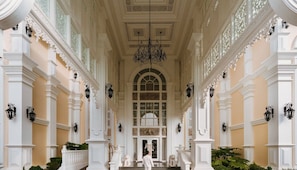 A grand hallway with ornate columns, a chandelier, and a statue at the end. - Ping Pura Riverside Resort & Spa (Hang Dong)