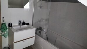 Ein Badezimmer mit Waschbecken, Spiegel und Dusche.