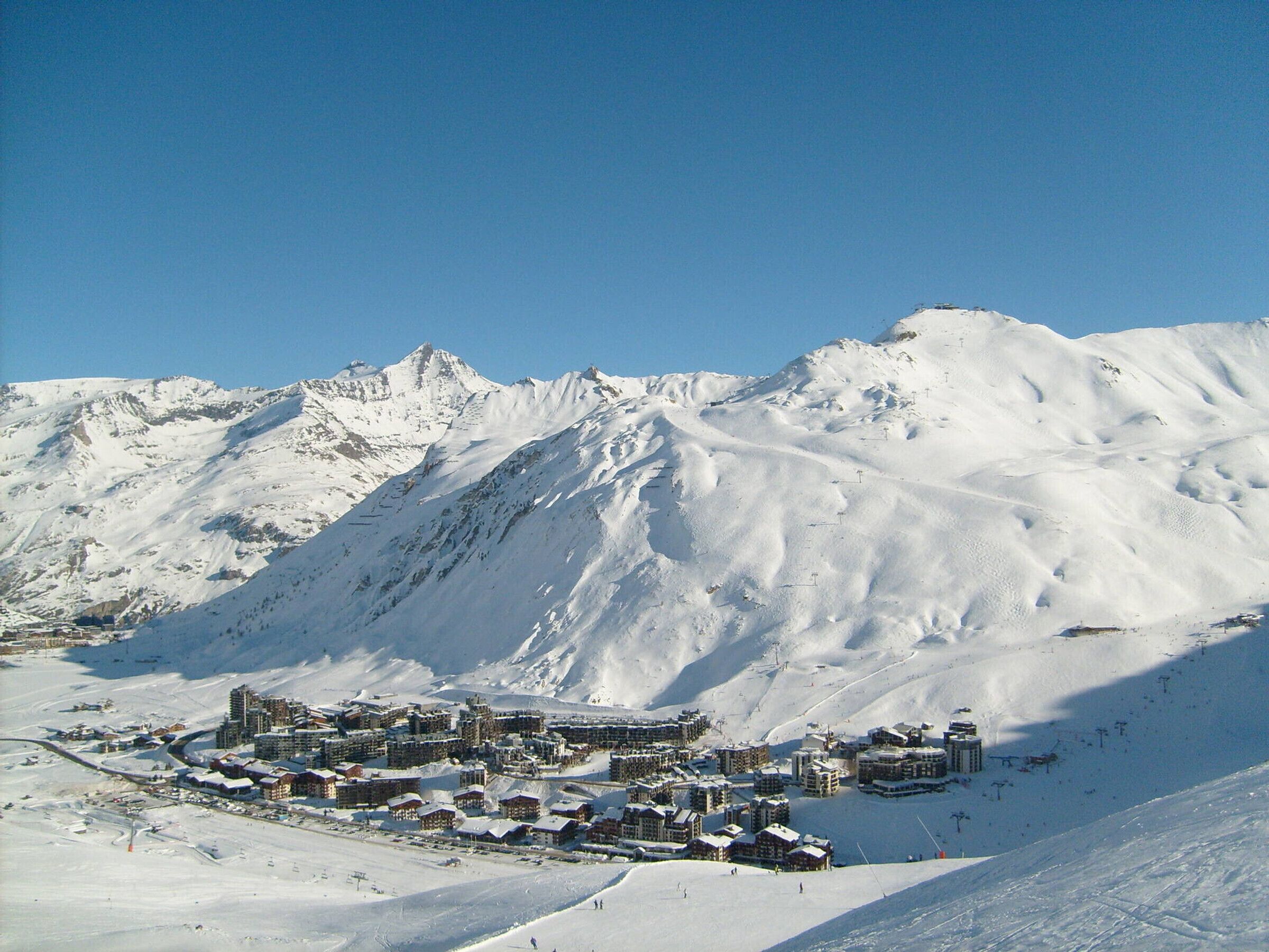 A snow-covered mountain with a resort town in the foreground.