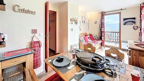 Ein Essbereich mit Tisch für vier Personen, einer Holzbänkchen und Blick ins Freie.