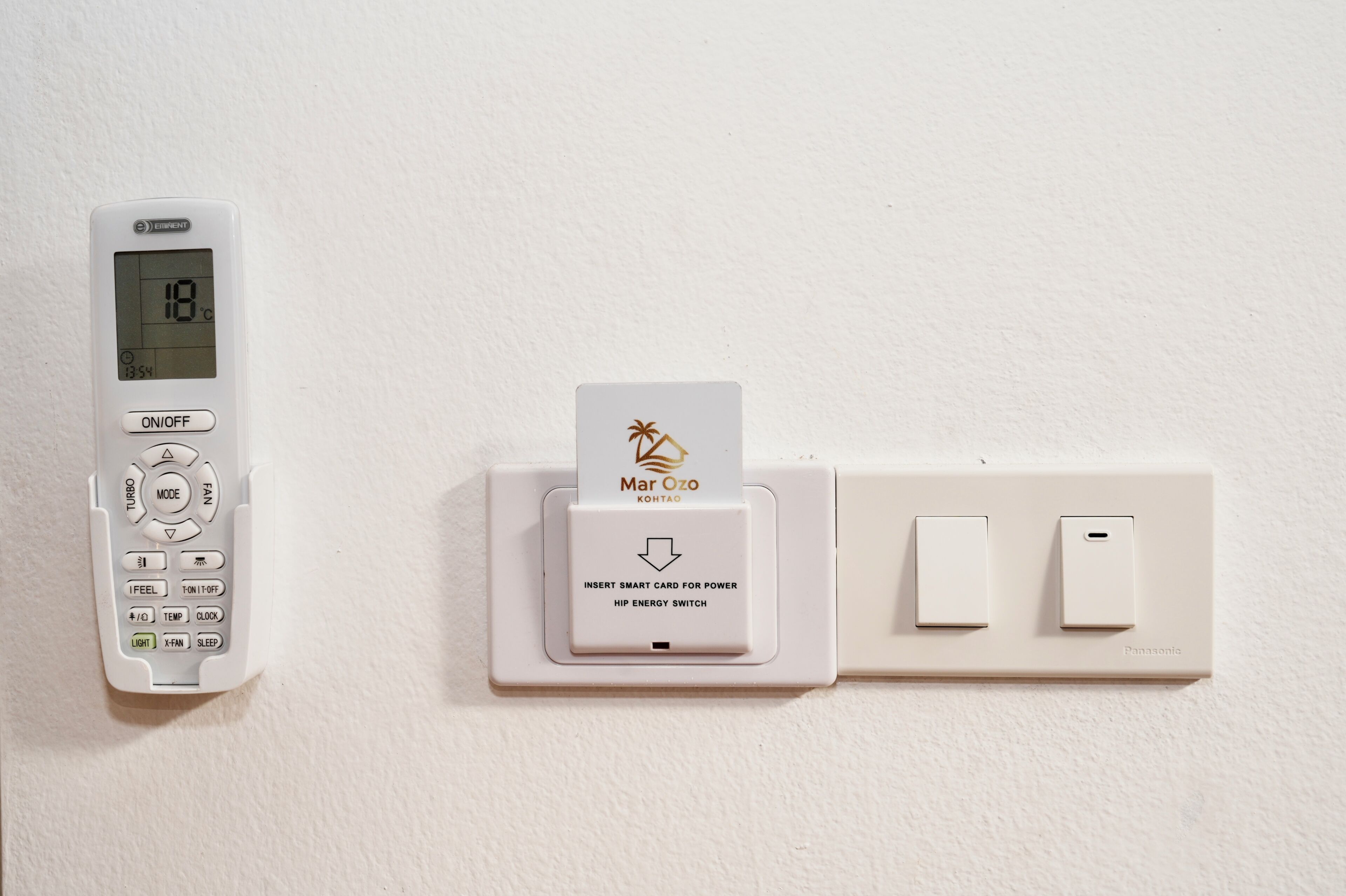 Un thermostat doté d’un écran numérique, d’un lecteur de carte à puce Mar Cozo Kohta et de deux interrupteurs muraux.