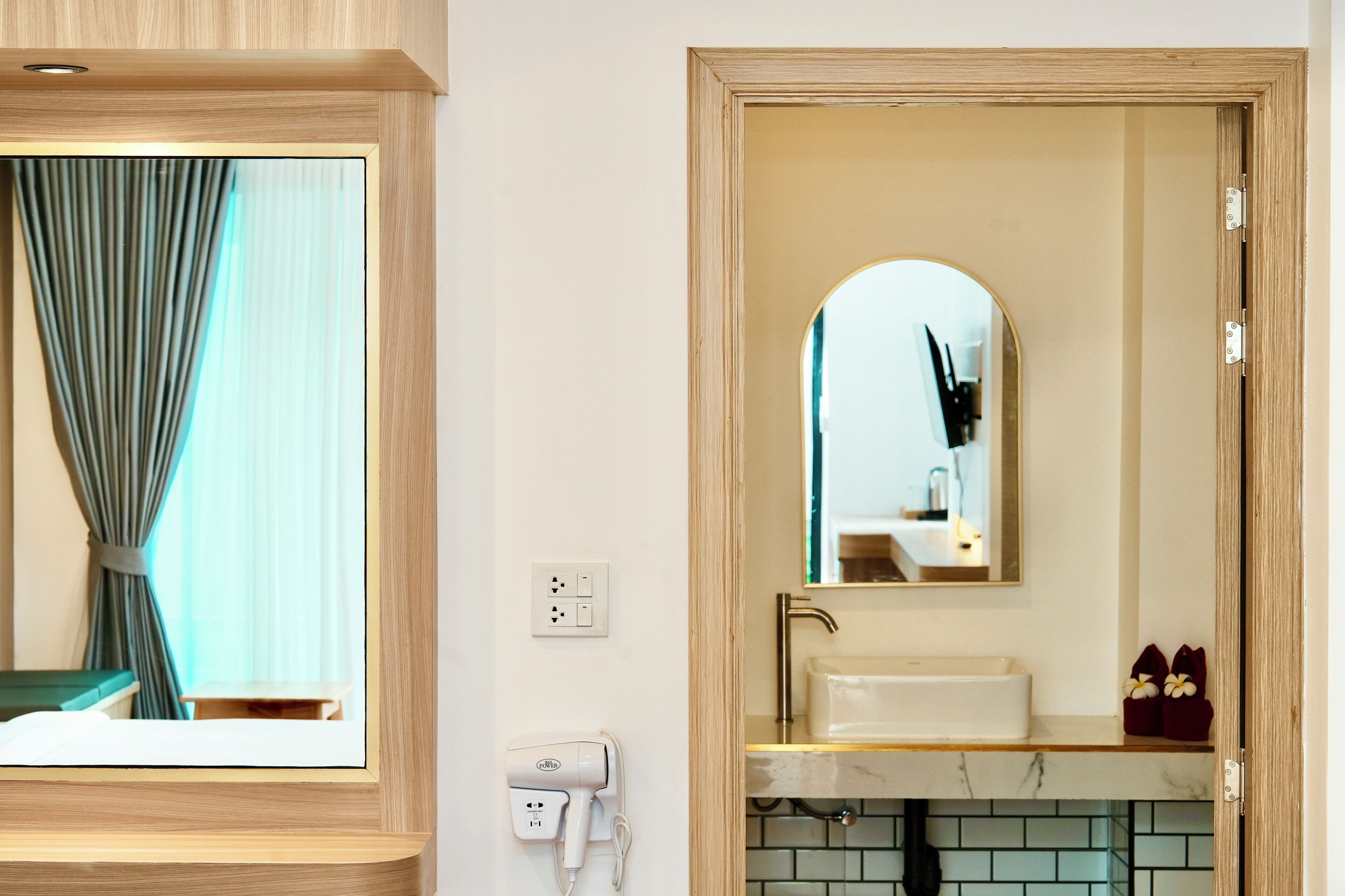 A bathroom with a wooden vanity, a mirror, a sink, and a towel rack.