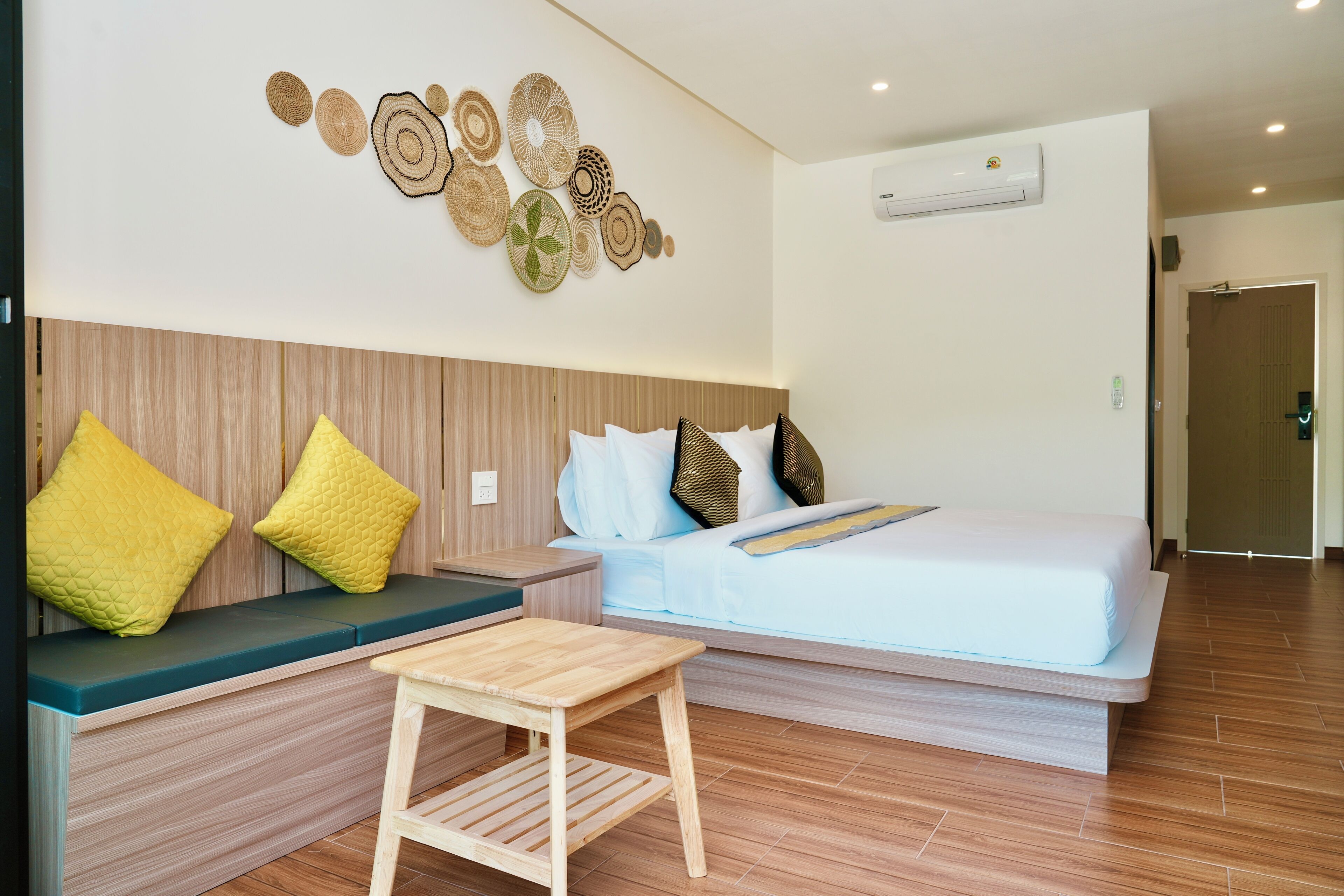 Una habitación de hotel moderna con cama, zona de estar y decoración en la pared.