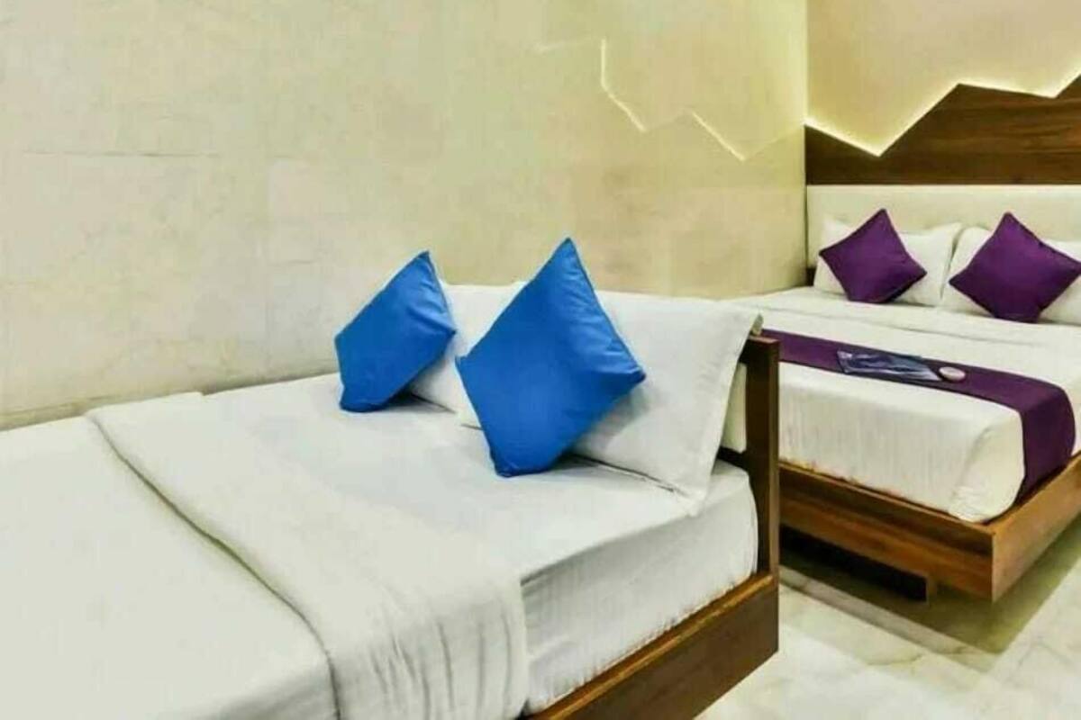 A hotel room with two beds, a wooden headboard, and a ceiling fan.
