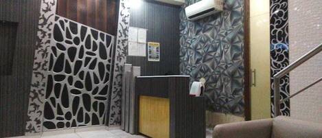 A reception area with a reception desk, a staircase, and patterned walls.