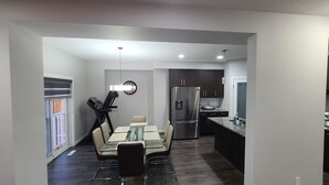 Una cocina moderna con un refrigerador de acero inoxidable, armarios oscuros y encimera de granito.