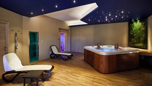 A modern spa room with a wooden floor, a hot tub, a lounge chair, and a ceiling with a starry design. - Hotel Alba D'Amore (Lampedusa)