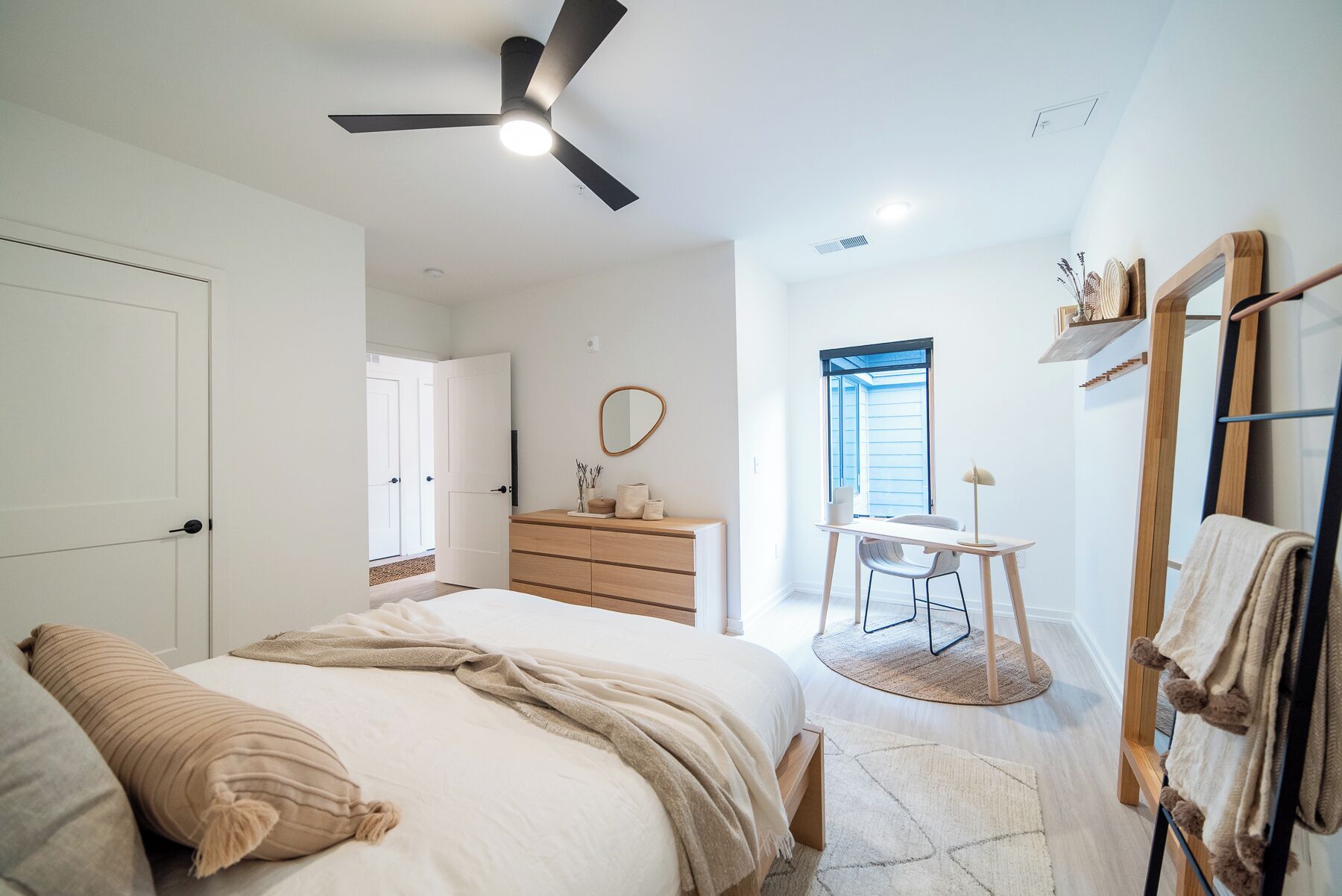 A bedroom with a bed, a dresser, a desk, and a chair.