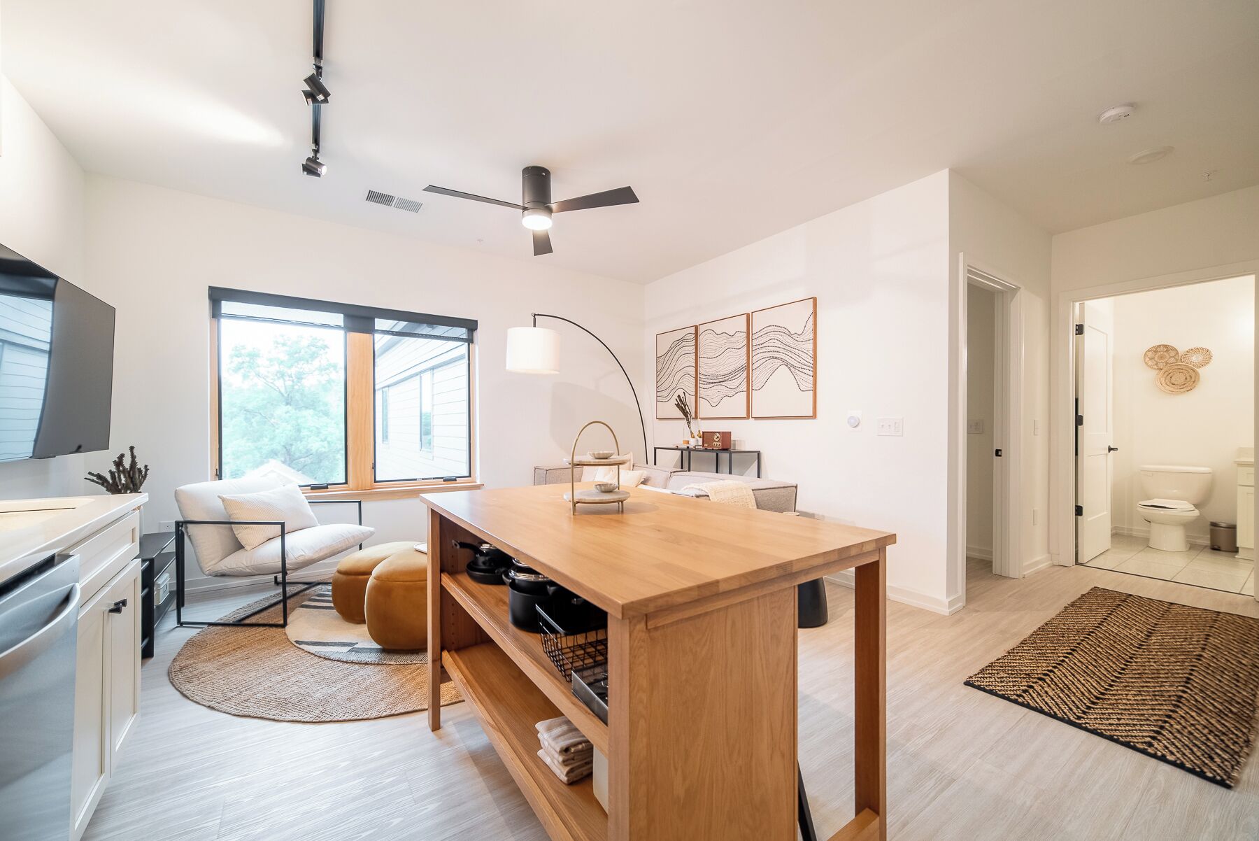 Una cocina moderna con una mesa de madera, horno empotrado y un amplio ventanal.