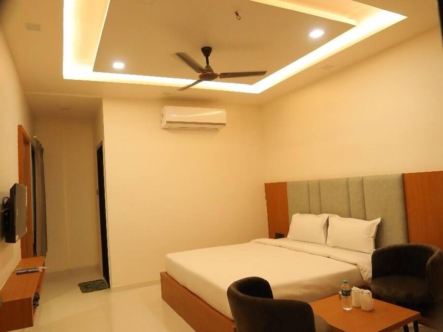 Habitación de hotel pequeña con cama, escritorio y una silla.
