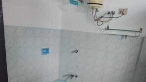 Kylpyhuone, jossa on kylpyamme, wc ja pyyheteline.