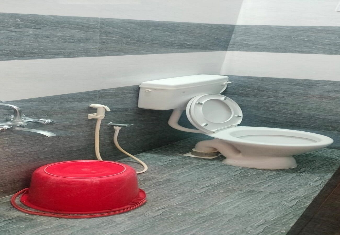 A bathroom with a toilet, bidet, and a red water heater.