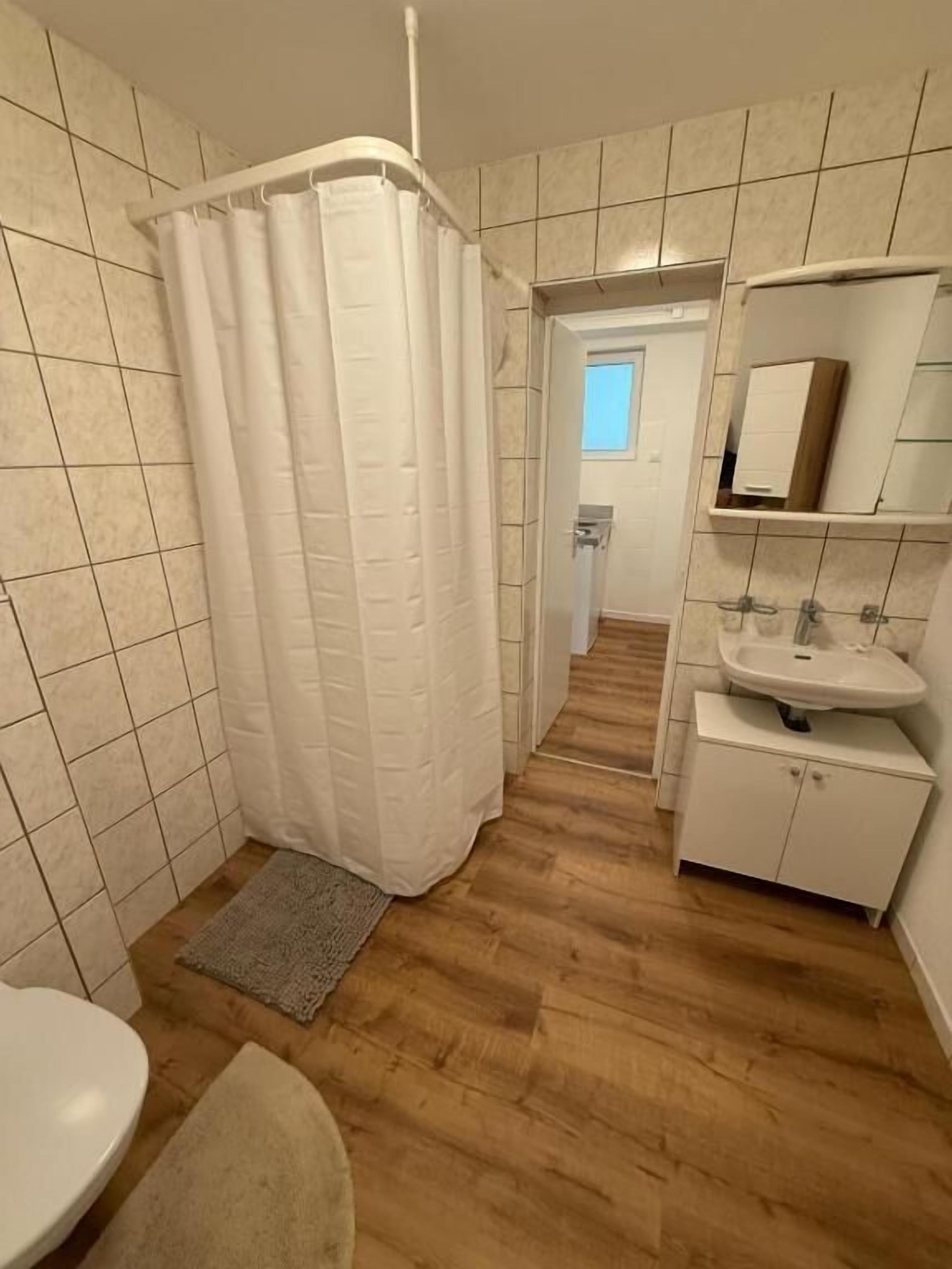 A bathroom with a shower, toilet, and sink.