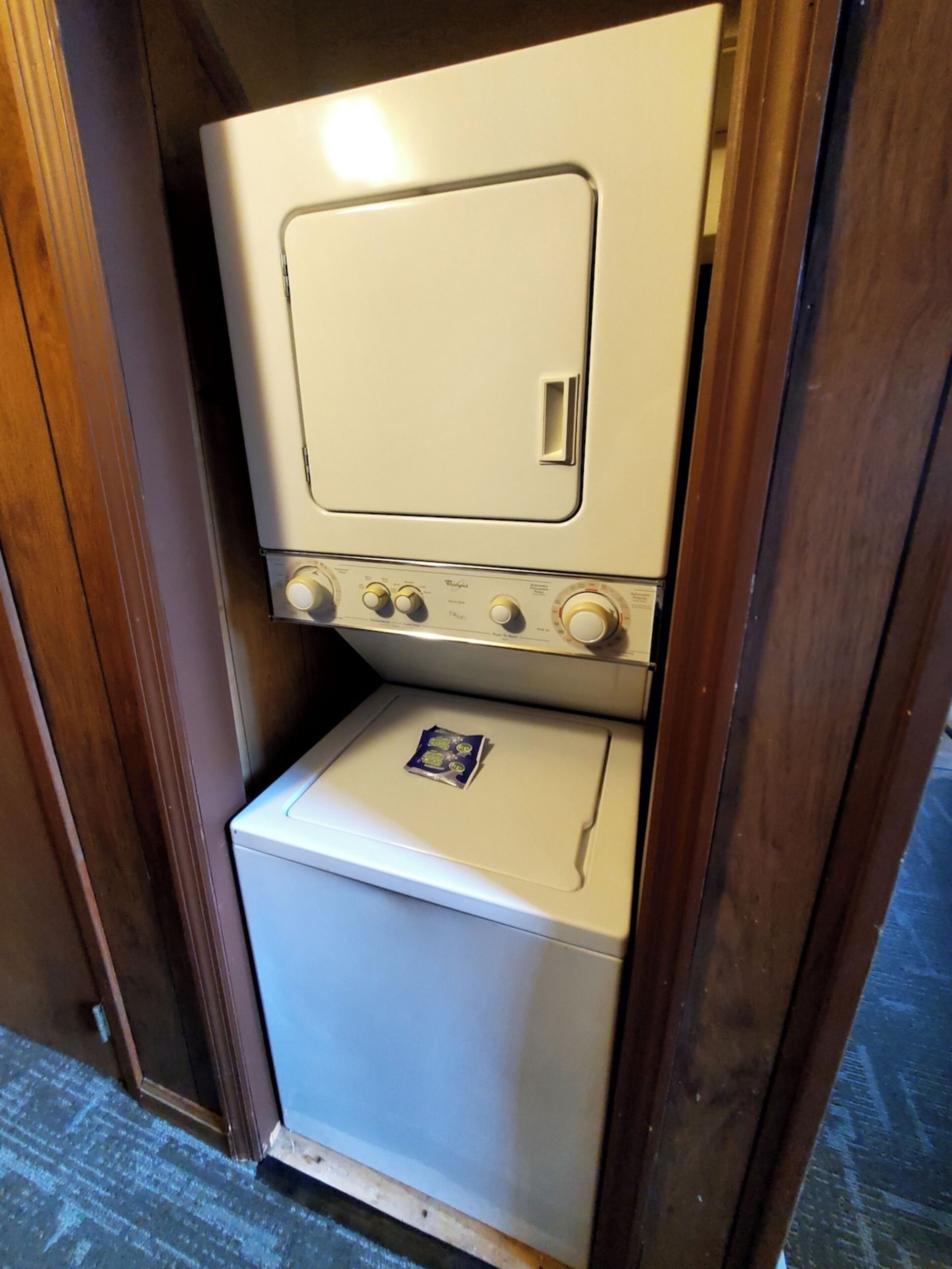 Un electrodoméstico pequeño y blanco, de dos puertas, con un panel de control y una puerta cuadrada en la parte superior.