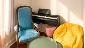 A room with a piano, a blue chair, a yellow bean bag, and a small round table. - 💙Studio Saint Victor, next to Notre Dame 🤍, lovely decorated, very quiet ❤️ (Paris)
