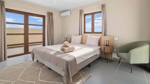 A hotel room with a bed, a chair, a nightstand, and a ceiling fan.