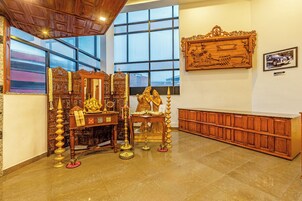 Una habitación con un ventanal grande, un armario de madera y una estatua.