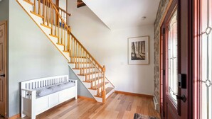Eine Treppe mit Holzwertungen, einer weißen Bank und einer Tür mit Glasscheiben.