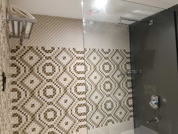 Un baño con baldosas estampadas, un perchero y una zona de ducha.