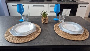 Et køkken med et moderne design, med en mørk bordplade, hvide skabe og en gaskomfur.