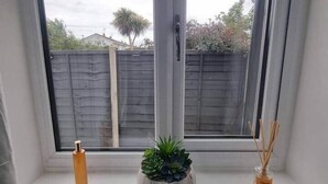 Ein Fenster mit Blick auf einen Holzzaun und einen Baum.