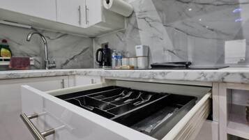 Geladeira, cafeteira/chaleira, talheres/pratos/utensílios de cozinha