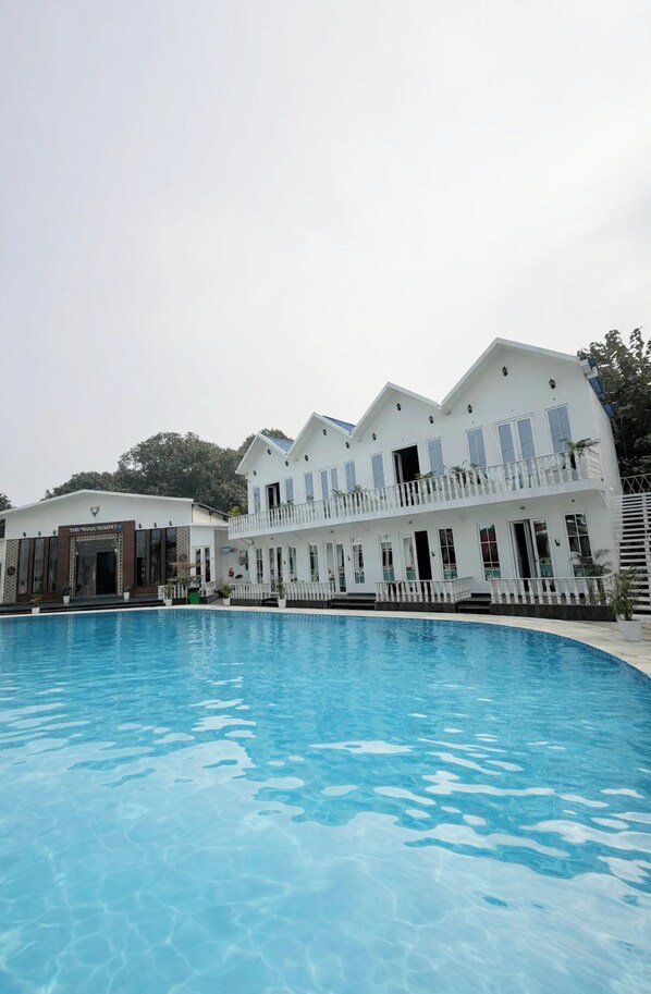 A large swimming pool with a white building in the background.