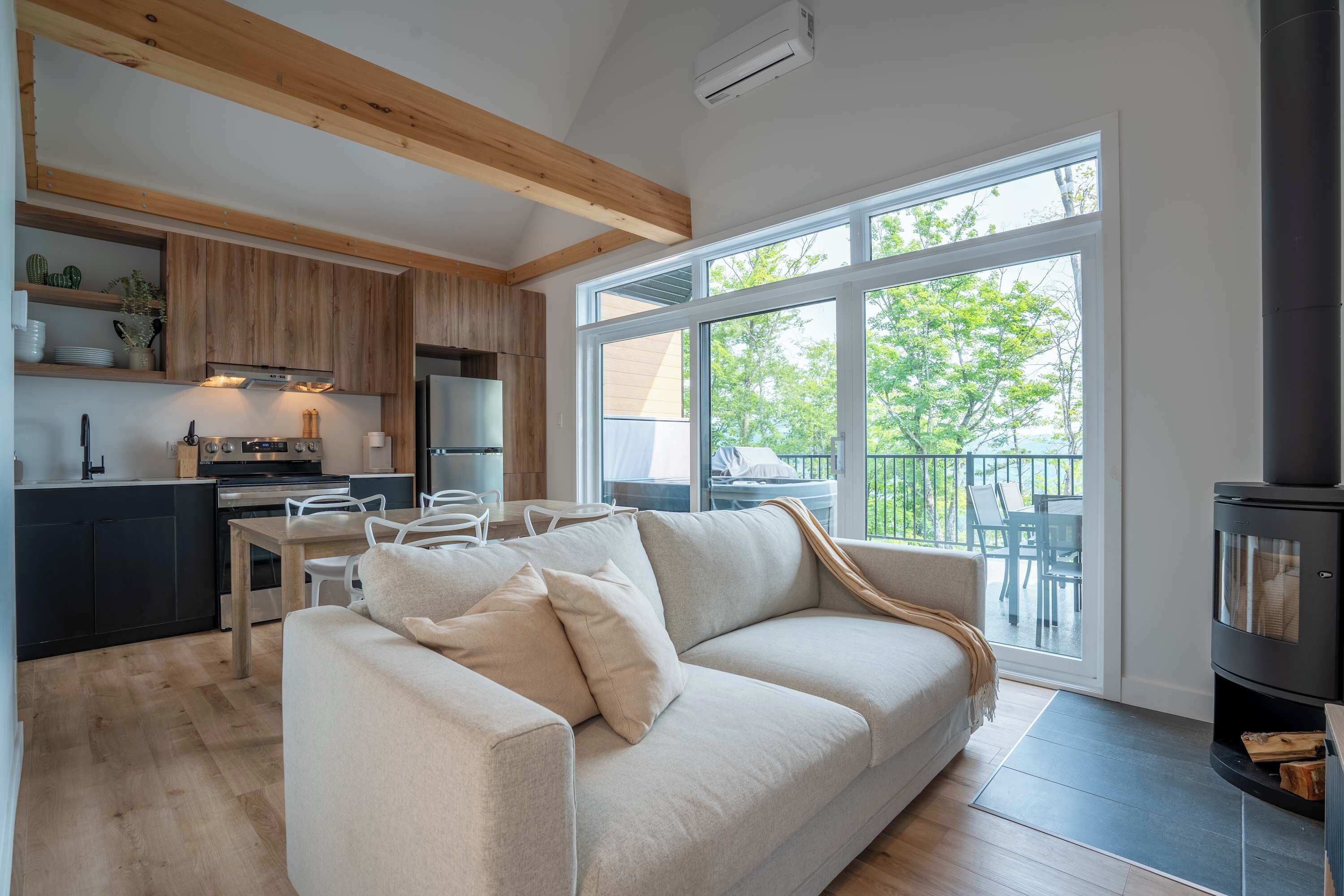 A modern living space with a kitchen, a sofa, and a fireplace.