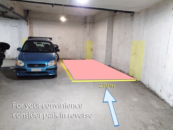 A parking garage with a blue car parked next to a pink and yellow marked area indicating a 2.70m space. - Zennova 72 Tsinari Luxury Suite (Thessaloniki)