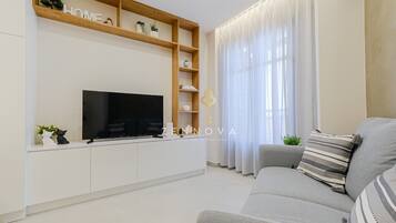 Deluxe-Apartment, Stadtblick | Wohnbereich | Flachbildfernseher