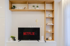 Departamento Deluxe, vista a la ciudad | Área de sala de estar | Televisión de pantalla plana 