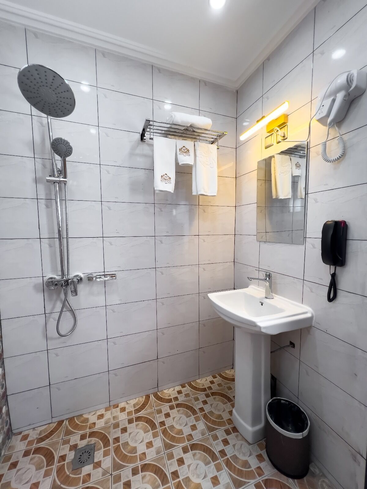 A modern bathroom with a shower, sink, and a mirror.