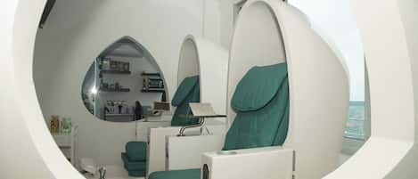 A modern bathroom with a circular mirror, green towels, and a view of the city.