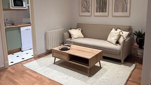 Un saló modern amb un sofà, una taula de centre i obra d'art a la paret.