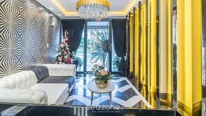 Ein modernes Wohnzimmer mit einer Couch, einem Couchtisch und einer Deckenleuchte.