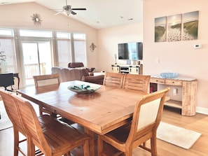 A dining area with a wooden table and chairs, a television, and artwork on the wall. - You're in Heaven #198 - Boat Dock, Pool, Hot Tub, Dog Friendly, Sleeps 9! (Topsail Beach)